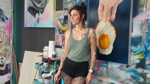 Künstlerin Maris Rauch ist auch bekannt als VolaneArt. Auf Instagram lässt sie ihre Fans teilhaben an der Entstehung ihrer Werke. | Maris Rauch Die Künstlerin Maris Rauch vor ihren Gemälden.