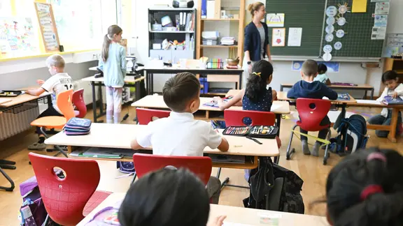 Schüler einer Grundschule sitzen in einer Schulstunde in ihrem Klassenzimmer. 