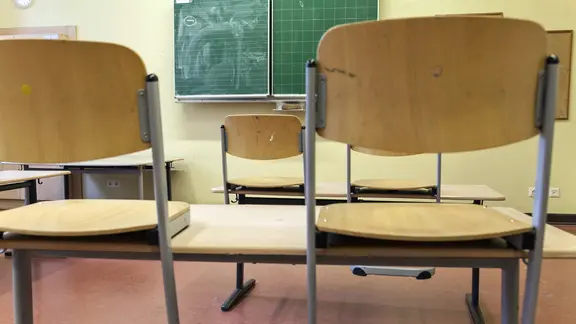 In einem Klassenraum stehen die Stühle auf den Tischen. | imago images / stpp In einem Klassenraum stehen die Stühle auf den Tischen.