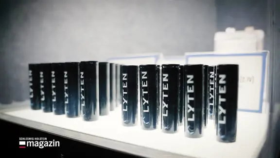 Mehrere schwarze zylinderförmige Batterien mit der Aufschrift „LYTEN“ stehen nebeneinander auf einer weißen Oberfläche. | Screenshot Mehrere schwarze zylinderförmige Batterien mit der Aufschrift „LYTEN“ stehen nebeneinander auf einer weißen Oberfläche.