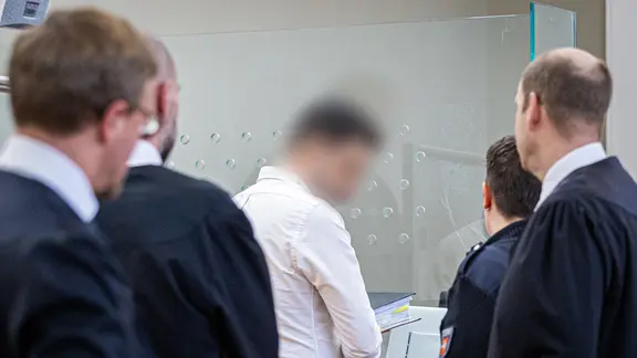 Der Angeklagte Yashar G. kommt im Rahmen des Prozesses gegen ihn gemeinsam mit Justizmitarbeitern in einen Saal des Landgerichts Hannover.