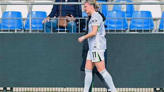 Alexandra Popp geht mit einer Betreuerin zusammen vor einer Tribüne. | picture alliance / DFB | Uwe Anspach Alexandra Popp geht mit einer Betreuerin zusammen vor einer Tribüne.