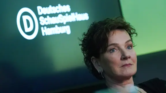 Karin Beier vor einer grünen Wand mit der Aufschrift "Deutsches Schauspielhaus Hamburg" | Marcus Brandt/dpa +++ dpa-Bildfunk +++ Karin Beier vor einer grünen Wand mit der Aufschrift "Deutsches Schauspielhaus Hamburg"