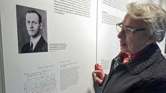 Ruth Gröne betrachtet in der Gedänkstätte Ahlem eine Porträtfotografie, die ihren Vater Erich Kleeberg zeigt.