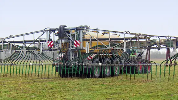 Ein Trecker mit einem Gülle-Anhänger auf einem Feld. | Screenshot Ein Trecker mit einem Gülle-Anhänger auf einem Feld.