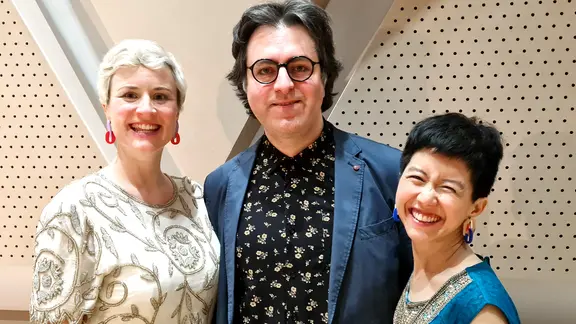 Zwei Frauen stehen lächelnd nach einem Konzert, in der Mitte steht ein Mann mit Brille (die Sopranistin Sophia Körber, links, die Pianistin Yun Qi Wong, rechts und Komponist Arsalan Abedian)