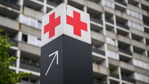 Ein Schild mit einem roten Kreuz weist den Weg zur Notaufnahme des Klinikums Region Hannover. | picture alliance/dpa, Julian Stratenschulte Ein Schild mit einem roten Kreuz weist den Weg zur Notaufnahme des Klinikums Region Hannover.