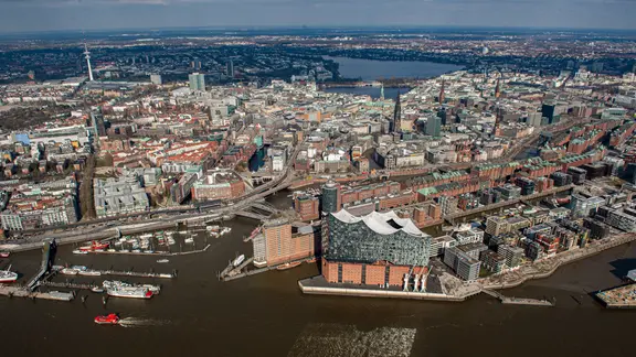 Das Luftbild zeigt die Elbphilharmonie im Hamburger Hafen, die Speicherstadt, die Hafencity, das Rathaus und im Hintergrund die Alster | Daniel Reinhardt/dpa Das Luftbild zeigt die Elbphilharmonie im Hamburger Hafen, die Speicherstadt, die Hafencity, das Rathaus und im Hintergrund die Alster