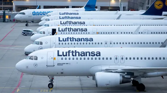 Abgestellte Flugzeuge der Lufthansa sowie eines der Discovery Airline stehen auf dem Flughafen Frankfurt. | picture alliance / dpa / Lando Hass Abgestellte Flugzeuge der Lufthansa sowie eines der Discovery Airline stehen auf dem Flughafen Frankfurt.