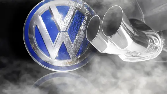 Das VW Logo, zur Hälfte beschmutzt, davor ein Auspuff (Montage) | imago, fotolia, Geisser, Mario Beauregard Das VW Logo, zur Hälfte beschmutzt, davor ein Auspuff (Montage)