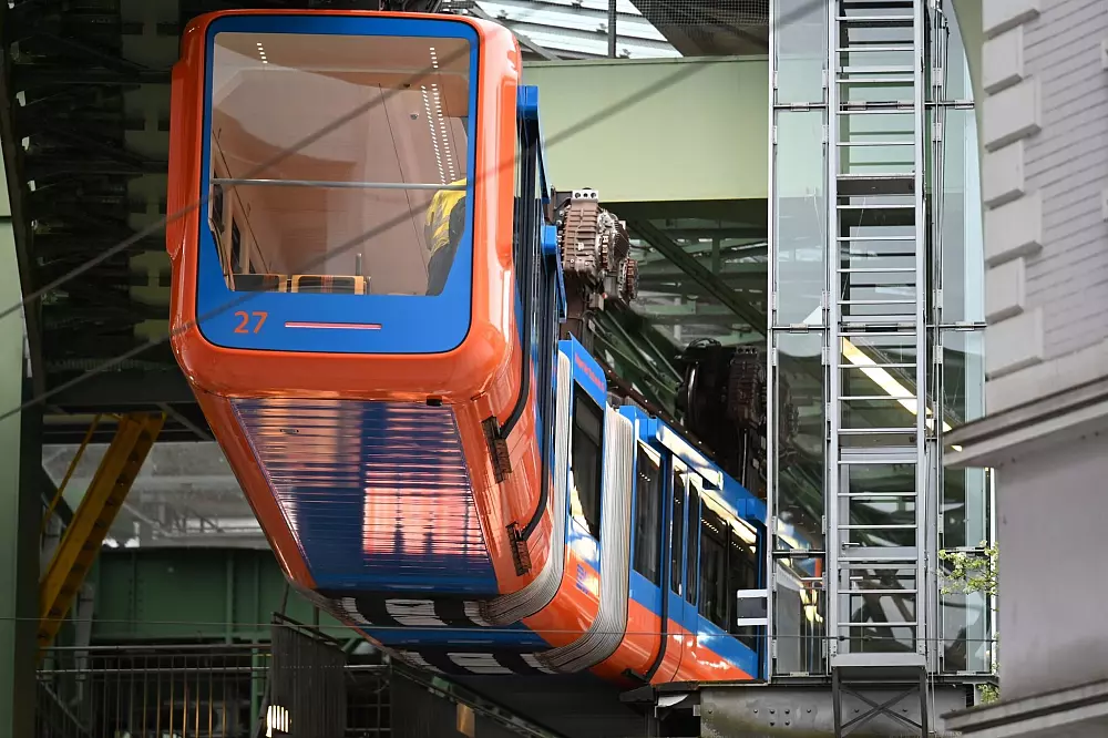 Ein moderner Wagen der Wuppertaler Schwebebahn ist orange-blau in der Optik der Baureihe 1972 gestaltet. Das Retro-Design der 1970er an einem Schwebebahn-Fahrzeug ist Teil der Aktionen zum Jubiläum 125 Jahre Schwebebahn im Jahr 2026. - © Volker Danisch/dpa
