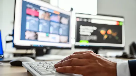 Auf zwei Computerbildschirmen sind Fotos und Videos zu sehen. | picture alliance / dpa, Uli Deck Auf zwei Computerbildschirmen sind Fotos und Videos zu sehen.