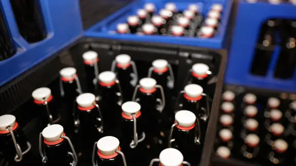 Bierflaschen stehen verschlossen in mehreren Kisten.