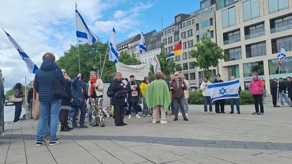 Zu einer Gegenkundgebung am Jungfernstieg sind rund 40 Personen erschienen. | NDR / Lisa Eißfeldt Teilnehmende eine Gegenkundgebung am Jungfernstieg halten Israel-Fahnen.