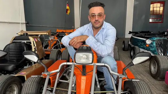 Rekar Joussef aus dem Kart-Team fährt bei den Touren selbst als Guide mit. | NDR Ein Mann sitzt in einer Lagerhalle in einem G-Kart.