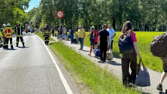 Die mehr als 500 Fahrgäste wurden aus dem Zug geholt und mit Bussen nach Sprötze gebracht. | JOTO Rettungskräfte und Passagiere nach dem Brand eines Zuges bei Sprötze