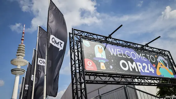 "Welcome to OMR24“" steht über dem Eingang zur Digital- und Marketingmesse Online Marketing Rockstars OMR in den Messehallen. | picture alliance/dpa, Christian Charisius "Welcome to OMR24“" steht über dem Eingang zur Digital- und Marketingmesse Online Marketing Rockstars OMR in den Messehallen.