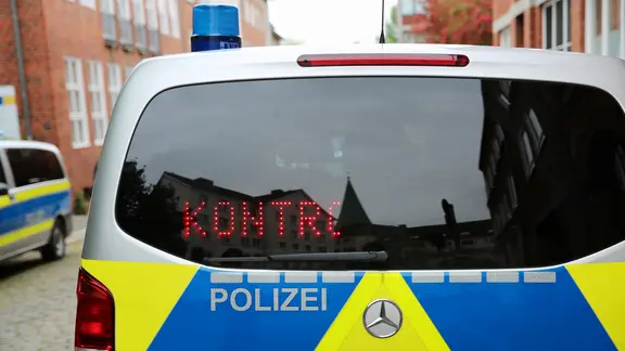 Schriftzug "KONTROLLE" ist an einer Rückscheibe eines Streifenwagens der Polizei eingeblendet.