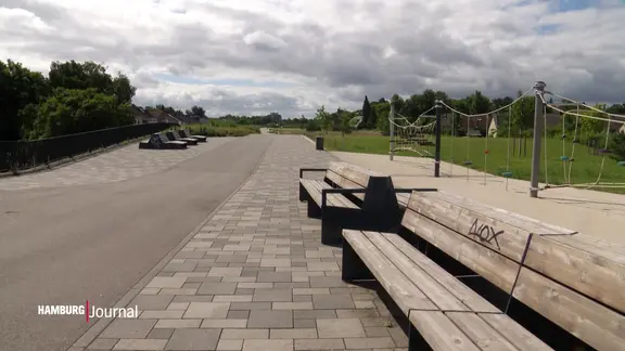 Mehrere Parkbänke an einem Weg mit Grünfläche .
