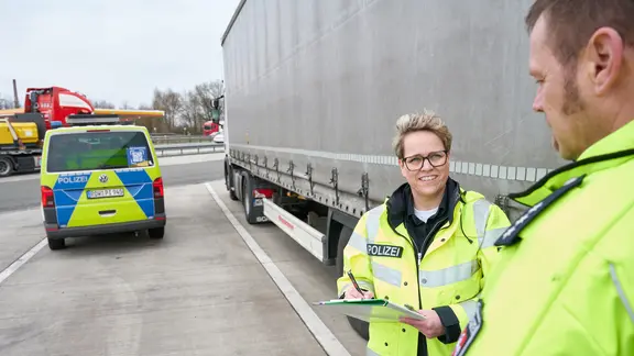 Polizeihauptkommissarin Andrea Möller von der Autobahnpolizei und ein Kollege kontrollieren an der A1 einen Lkw.