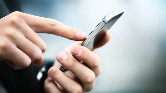 Person tippt auf ein Smartphone