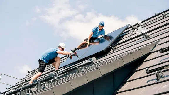 Ein Solar-Panel wird auf einem Dach installiert. | picture alliance / Westend61 | Franci Leoncio Ein Solar-Panel wird auf einem Dach installiert.