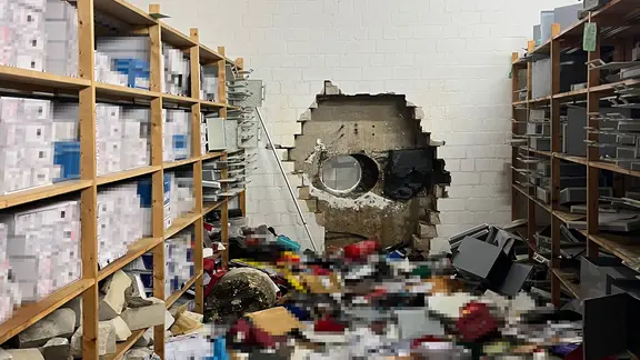Bei dem Raub in Gelsenkirchen schätzt die Polizei den Schaden auf mehr als 100 Millionen Euro. | picture alliance/dpa/Polizei Gelsenkirchen Ein Loch in der Mauer einer Gelsenkirchener Sparkasse.