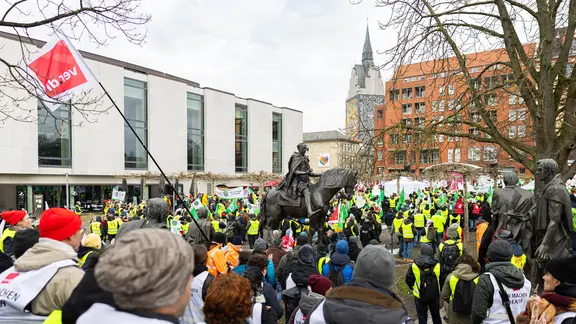 Demonstrierende stehen auf einer Kundgebung in Hannover. | picture alliance/dpa, Michael Matthey Demonstrierende stehen auf einer Kundgebung in Hannover.
