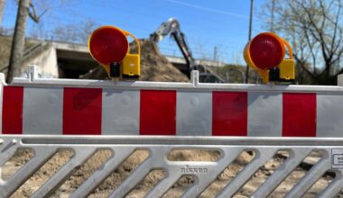 Eine Baustellenabsperrung in der Schlichtallee in Rummelsburg steht vor einem Baustellenbereich mit Bagger. Die anhaltende Sperrung und die Verzögerungen bei den Arbeiten führen weiterhin zu Umwegen für Autofahrer.