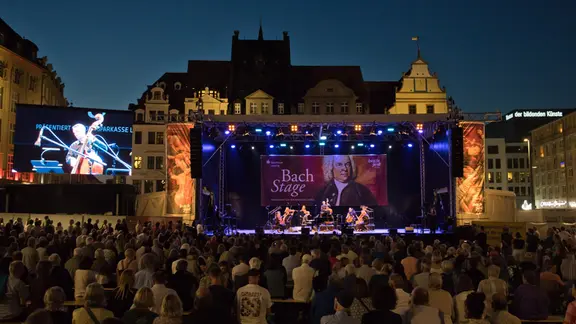 Die große Bühne auf dem Leipziger ist eine Einladung an alle, Bachs Musik kennenzulernen. | Bach-Archiv Leipzig Blick über ein großes Publikum auf eine Open-Air-Bühne.