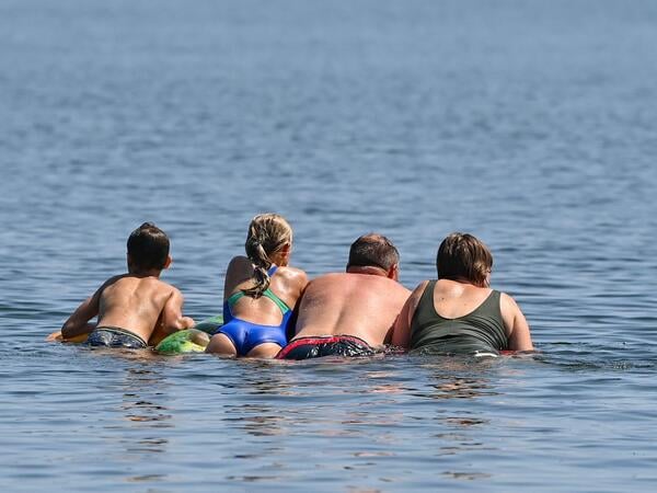 ARCHIV - 19.07.2022, Brandenburg, Storkow: Eine Familie schwimmt auf einer Luftmatratze im Wasser eines Sees. (zu dpa: «Was man gut bei Hitze unternehmen kann») Foto: Patrick Pleul/dpa +++ dpa-Bildfunk +++