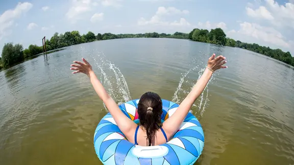 Uetze: Ein junge Frau badet mit einem Schwimmreifen im Irenensee