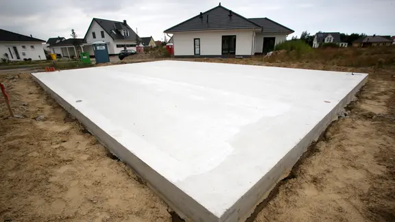 Ein Baugrundstück für ein neues Einfamilienhaus mit einer Grundplatte. | dpa/Bernd Wüstneck Ein Baugrundstück für ein neues Einfamilienhaus mit einer Grundplatte.