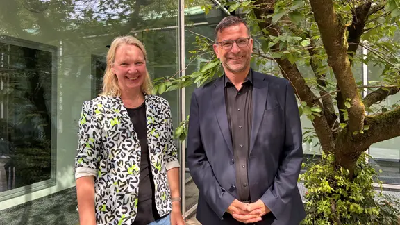 Moderatorin Friederike Westerhaus zusammen mit dem neuen Intendanten der Staatsoper Hannover Bodo Busse. | Claudia Christophersen / NDR Eine Frau und ein Mann stehen nebeneinander vor einer Glasfront.
