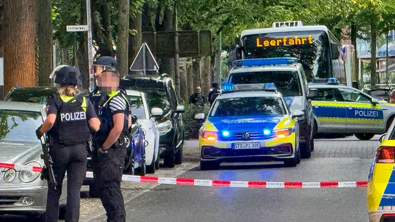 Die Polizei sperrte den Tatort am Abend weiträumig ab. Die Täter sind flüchtig. | JOTO Polizeiwagen und bewaffnete Polizisten stehen in der Buxtehuder Innenstadt.