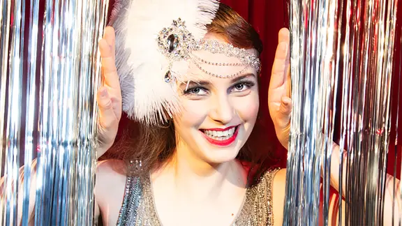 eine Frau hinter einem Glittervorhang