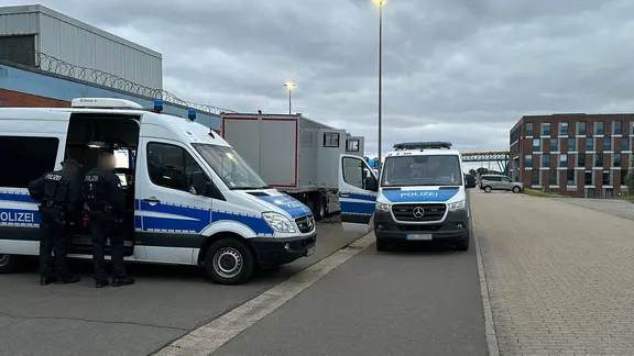 Die Polizei ist mit mehreren Fahrzeugen und zahlreichen Einsatzkräften vor Ort. Sie wird den Transport auch auf der Straße begleiten. | NDR, Ben Armstrong EIn Polizei- Trupp in Brunsbüttel