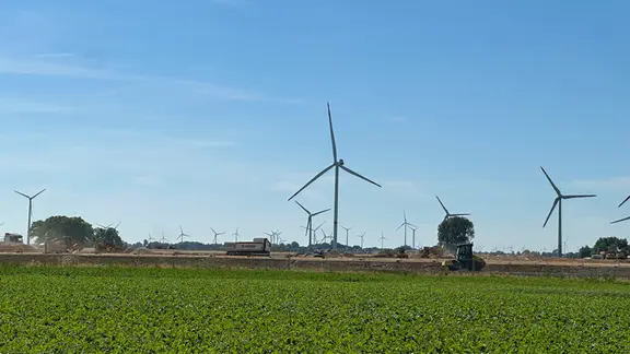Windräder im Feld mit Bauarbeiten | Ben Armstrong Windräder im Feld mit Bauarbeiten
