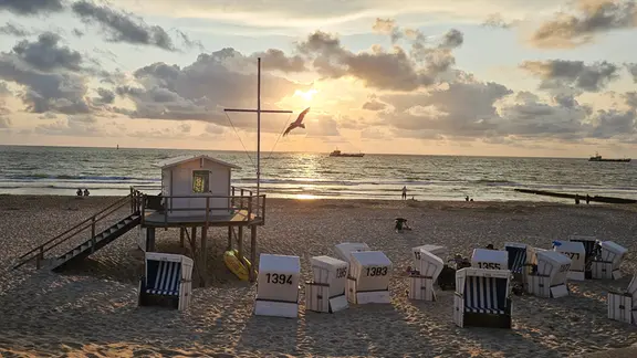 Tanja Vollmers aus Schleswig (Landkreis Schleswig), machte dieses Bild auf Sylt, in Erinnerung an den Sommer. | Tanja Vollmers Ein Strand mit Strandkörben versehen bei einem Sonnenuntergang.