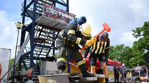 Ein Feuerwehrmann macht bei einem Feuerwehr-Wettbewerben auf Messe Interschutz mit. | picture alliance/dpa | Julian Stratenschulte Ein Feuerwehrmann macht bei einem Feuerwehr-Wettbewerben auf Messe Interschutz mit.