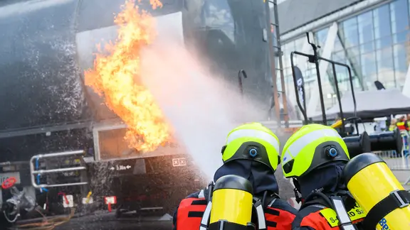 Feuerwehrmänner zeigen an einem Brandsimulator auf der Interschutz-Messe die Brandbekämpfung an einem brennenden Kesselwagen. | picture alliance, dpa | Julian Stratenschulte Feuerwehrmänner zeigen an einem Brandsimulator auf der Interschutz-Messe die Brandbekämpfung an einem brennenden Kesselwagen.