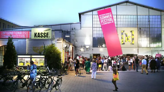 Viele Menschen stehen vor dem Gebäude des Kulturzentrums "Kampnagel" in Hamburg in einer Sommernacht. | Kampnagel, Anja Beutler Viele Menschen stehen vor dem Gebäude des Kulturzentrums "Kampnagel" in Hamburg in einer Sommernacht.