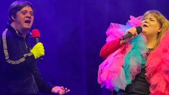 Dario Redecker und eine andere Schauspielerin stehen mit Mikrofonen auf der Bühne und singen. | NDR, Foto: Agnes Bührig Dario Redecker und eine andere Schauspielerin stehen mit Mikrofonen auf der Bühne und singen.