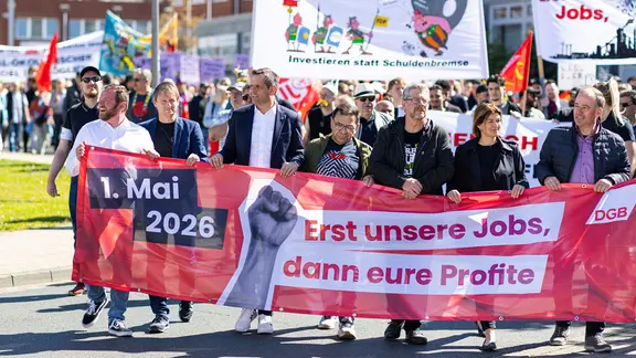 Olaf Lies (SPD), Ministerpräsident von Niedersachsen, hält zusammen mit anderen Teilnehmern einen Banner des Deutscher Gewerkschaftsbunds mit der Aufschrift: "1. Mai 2026; Erst unsere Jobs, dann eure Profite". | dpa, Michael Matthey Olaf Lies (SPD), Ministerpräsident von Niedersachsen, hält zusammen mit anderen Teilnehmern einen Banner des Deutscher Gewerkschaftsbunds mit der Aufschrift: "1. Mai 2026; Erst unsere Jobs, dann eure Profite".