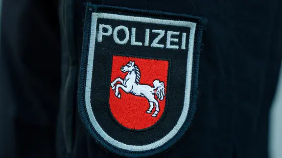 Der 19-Jährige trug ein Hemd der Polizei mit Abzeichen sowie eine Diensthose. (Themenbild) | dpa, Georg Wendt Das Ärmelabzeichen der Polizei Niedersachsen zeigt das Landeswappen, das sogenannte Sachsenross