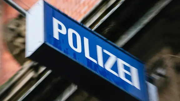 An einer Hausfassade hängt ein Leuchtschild mit der Aufschrift Polizei. | NDR, Julius Matuschik An einer Hausfassade hängt ein Leuchtschild mit der Aufschrift Polizei.