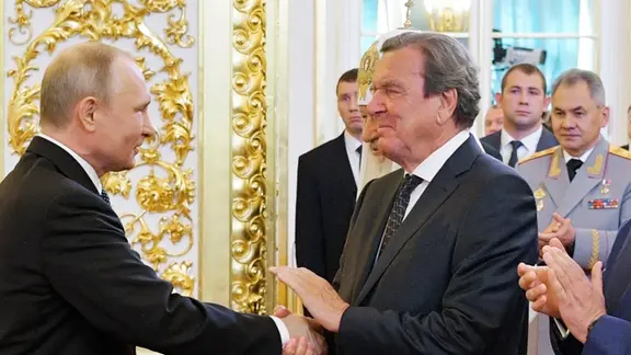 Archivbild: Wladimir Putin, Präsident von Russland, begrüßt Gerhard Schröder, ehemaliger Bundeskanzler, nach seiner Wiederwahl zum russischen Präsidenten. | picture alliance/dpa | Alexei Druzhinin Archivbild: Wladimir Putin, Präsident von Russland, begrüßt Gerhard Schröder, ehemaliger Bundeskanzler, nach seiner Wiederwahl zum russischen Präsidenten.