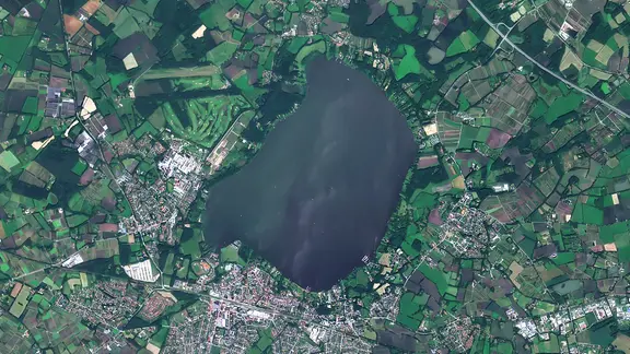 Selbst aus dem All sind im Juni 2026 Blaualgen im niedersächsischen See Zwischenahner Meer zu sehen. | Vertical52 / Planet Scope Ein Satellitenbild zeigt das Zwischenahner Meer im Landkreis Ammerland.