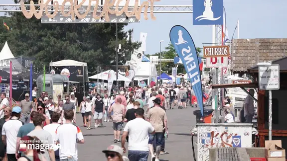 Menschen spauzieren über die Kieler Woche | Screenshot Menschen spauzieren über die Kieler Woche