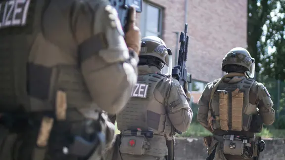 Das SEK rückte an, weil zunächst unklar war, um was für eine Waffe es sich handelte. (Themenbild) | NDR, Julius Matuschik Drei Einsatzkräfte des Spezialeinsatzkommandos stehen mit aufgerichtetem Maschinengewehr hintereinander.